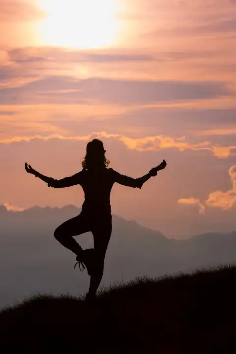 Ein Mädchen übt während eines Ausflugs in den Bergen Yoga-Positionen.