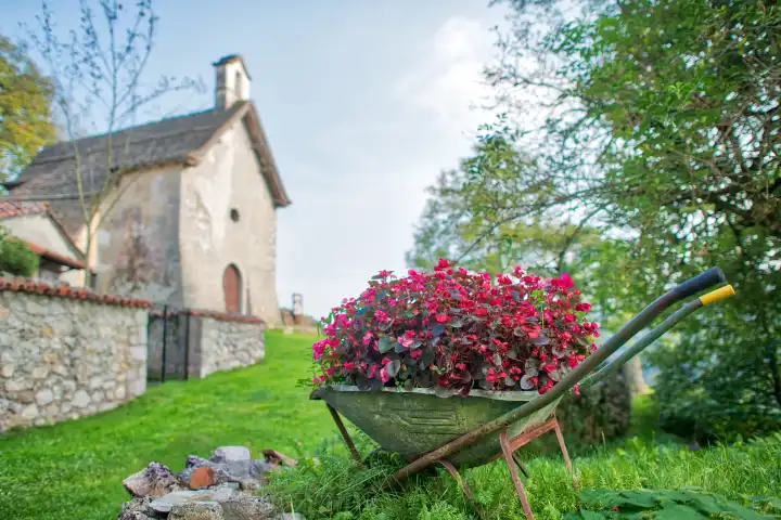 Schubkarre voller Blumen in einem Dorf in Norditalien.