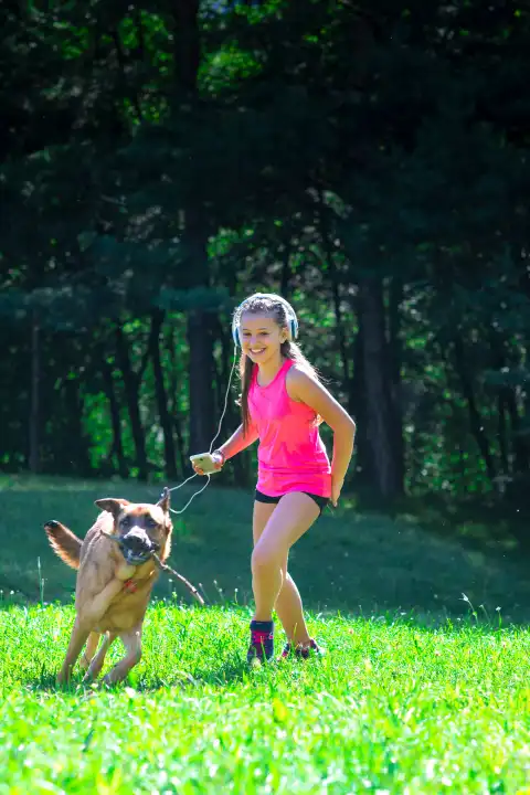 Little girl plays with her German shepherd dog in the meadow.