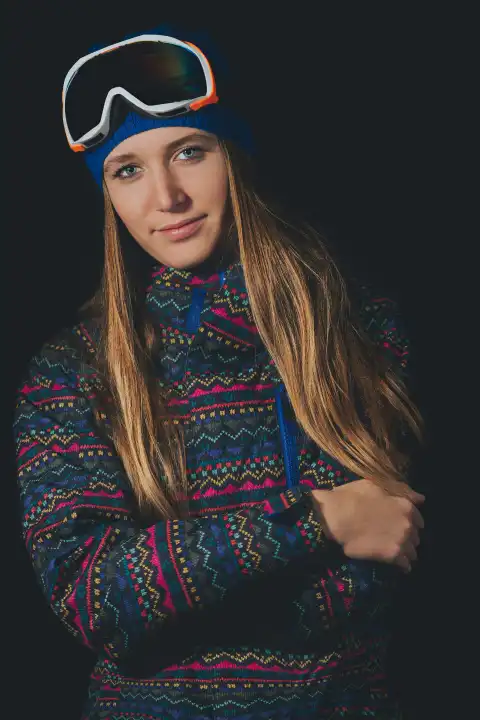 Beautiful blond girl with long hair in snowboard clothing with black background.