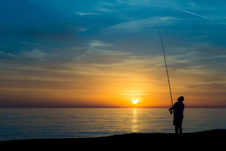 Fisherman on the beach at sunset