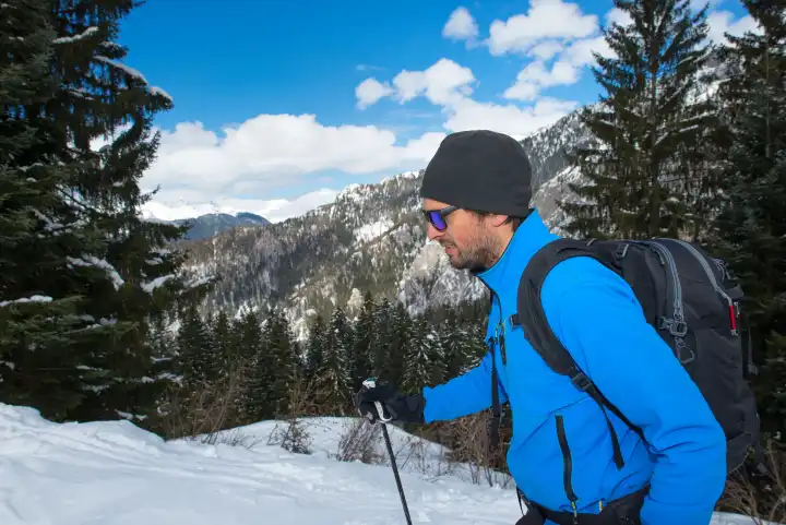 Mann in Aktion bei einer Winterwanderung in den Bergen