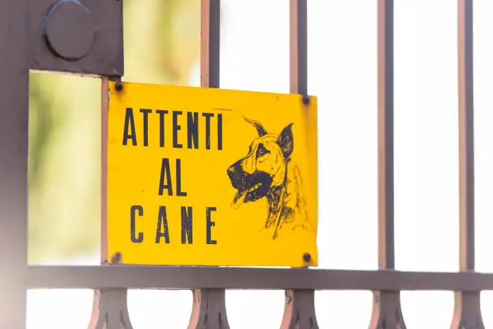 Zeichen der Aufmerksamkeit für den Hund, das vor dem Tor eines Privathauses in italienischer Sprache hängt.