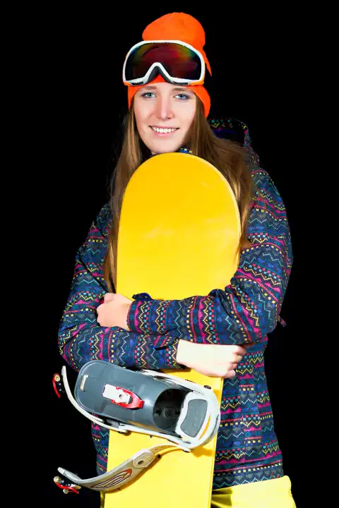 Sportliches Mädchen mit Snowboard auf schwarzem Hintergrund im Studio.