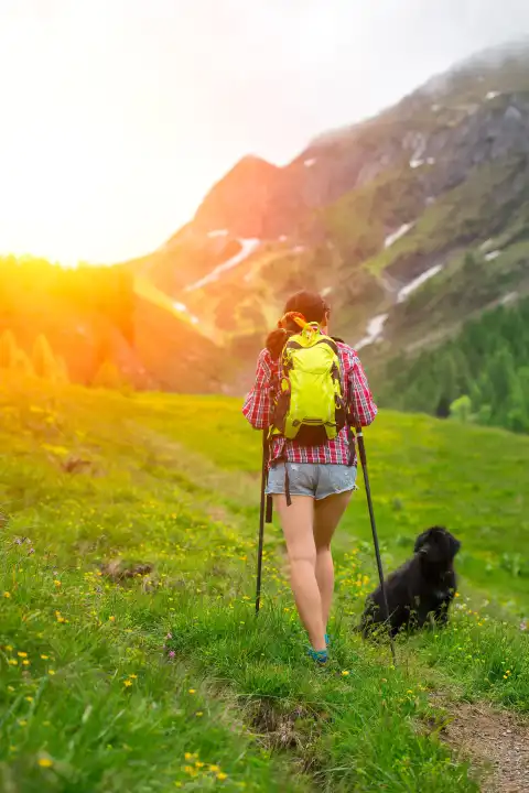Hiking on mountain trail of a girl with her dog