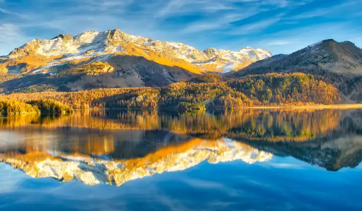 Alpine lake in late autumn with reflections of mountains in Switzerland near Sankt Moritz