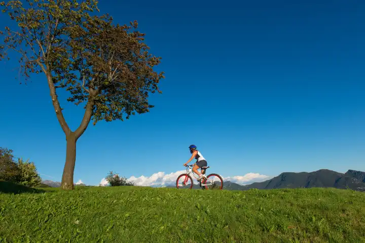 Girl with mountain bike in the meadows