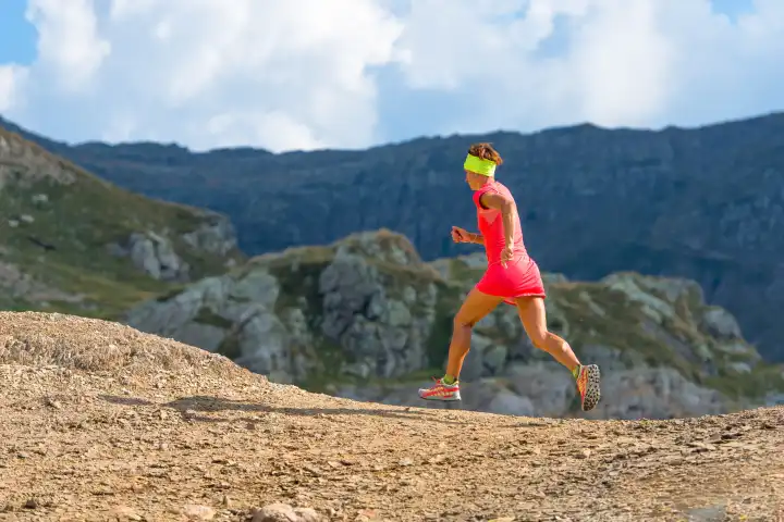 Female athlete runs in the mountains practice skyrunning with determination