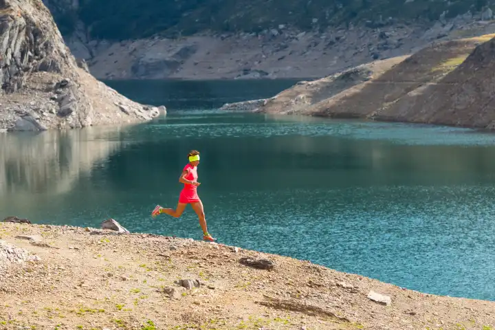 Running in the great outdoors mountain among alpine lakes, a woman alone