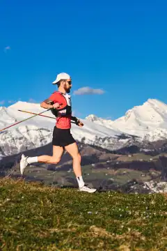 Sporty man practicing Nordic walking in the hills alone