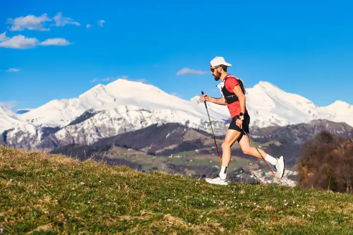 Young sporty man practicing Nordic walking in the Italian Alps