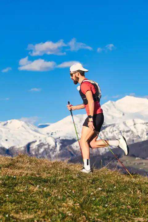 Young sporty man practicing Nordic walking in the Italian Alps