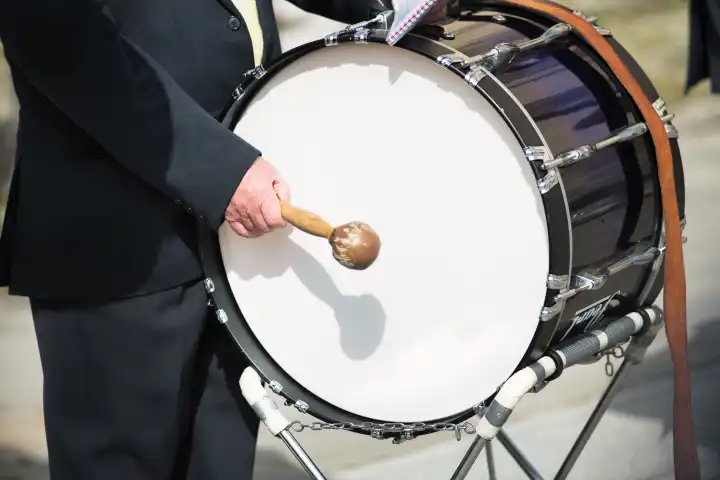 Details of hands playing the bass drum during a popular festival in northern Italy