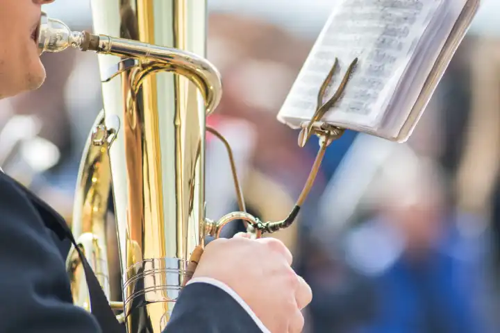 Details of hands playing tuba bass during a popular festival in northern Italy