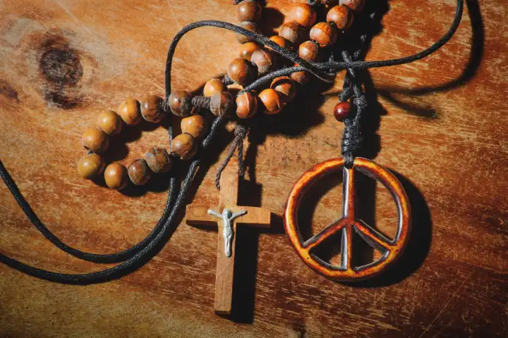 Symbol des Friedens und das Kruzifix auf einem Holztisch