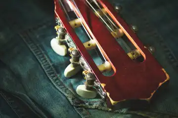 Kopfplatte einer Konzertgitarre auf einer Jeans liegend
