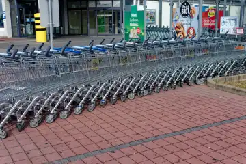 Symbolbild, Einkaufen im Einzelhandel: In einer geschwungenen Reihe zusammengeschobene Einkaufswagen