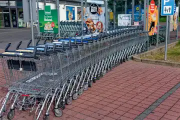 Symbol image, retail shopping: shopping carts pushed together in a curved row.
