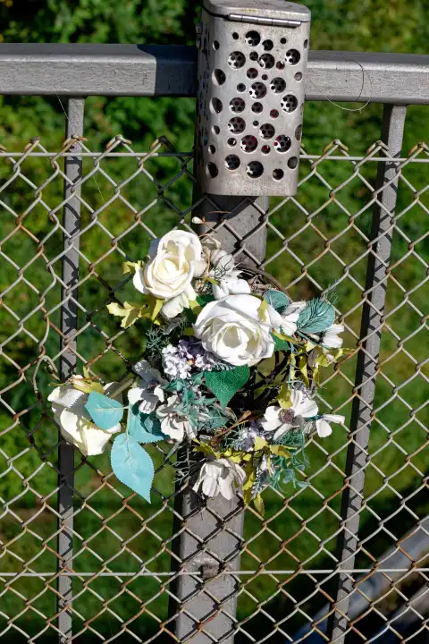 Withered wreath of flowers on a bridge railing in memory of traffic fatality