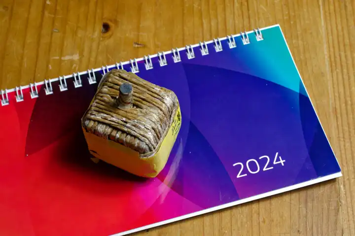 Symbolbild: Jahreswechsel, Neujahr, Kalender für 2024 und Feuerwerkskörper