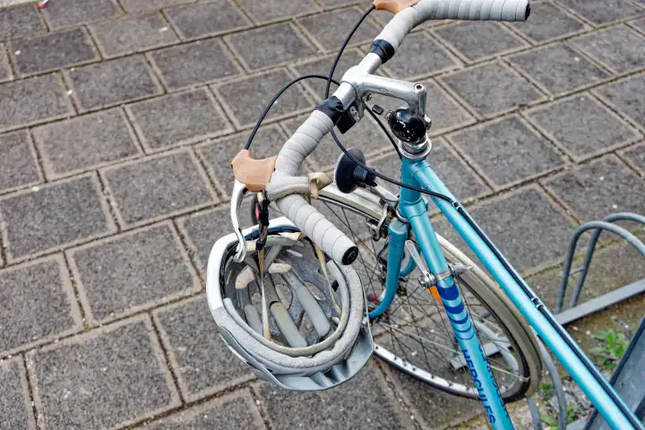 Sicherheit im Verkehr: Fahrradhelm hängt am Lenker eines Fahrrads