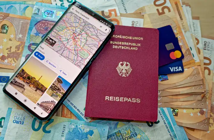 German passport with banknotes, credit cards and smartphone with app with map and sights