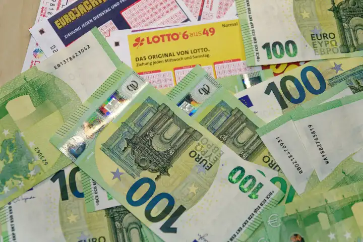 Glücksspiel, Lotto, Toto, verschiedene Tippscheine staatlicher Lotterien mit Geldscheinen