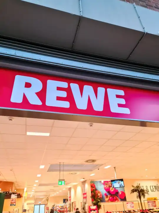 Kiel, Germany - 24.Feburary 2022: The logo of the supermarket chain ReWe above the entrance area of a supermarket