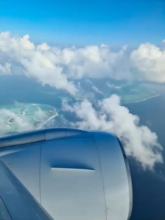 Blick von einem Flugzeug auf den Motor und die Wolken über den Malediven