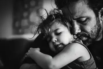 An emotional fathers day shot in black and white with a child in fathers arms AI generated
