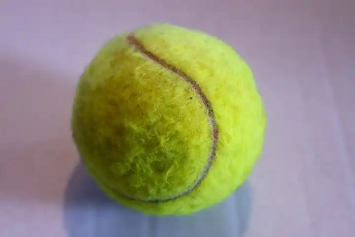 Colorful tennis ball in front of a white background