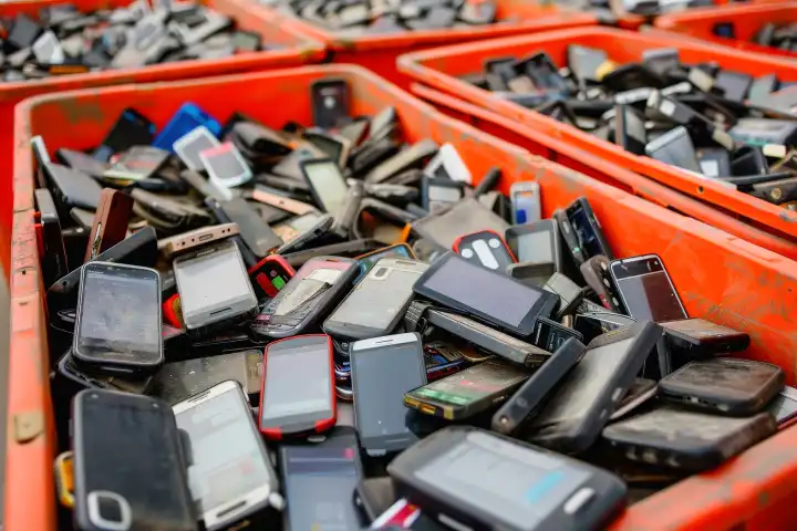 Eine Tonne voller alter Smartphones auf dem E-Schrottplatz, generiert mit KI