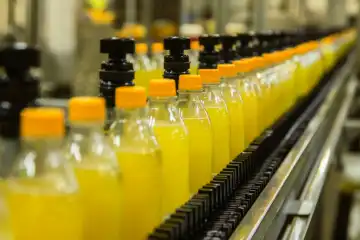 A bottling line for yellow lemonade bottles, generated with AI