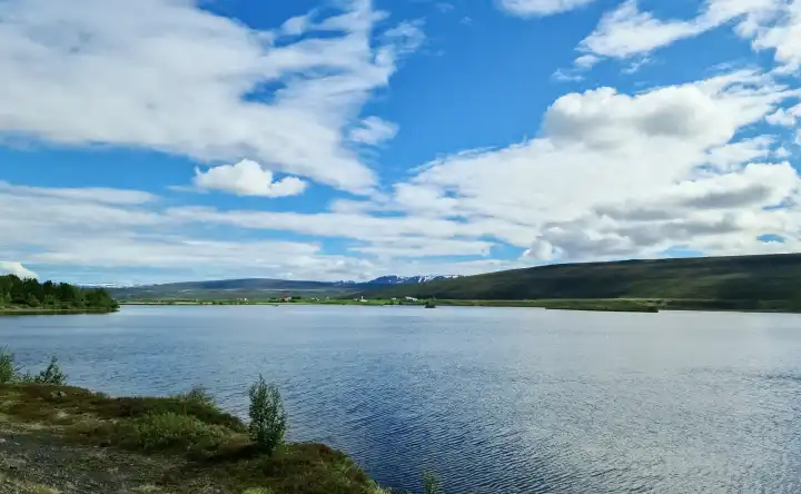 View of a beautiful lake with spectacular clouds and mountains in the Icelandic landscape
