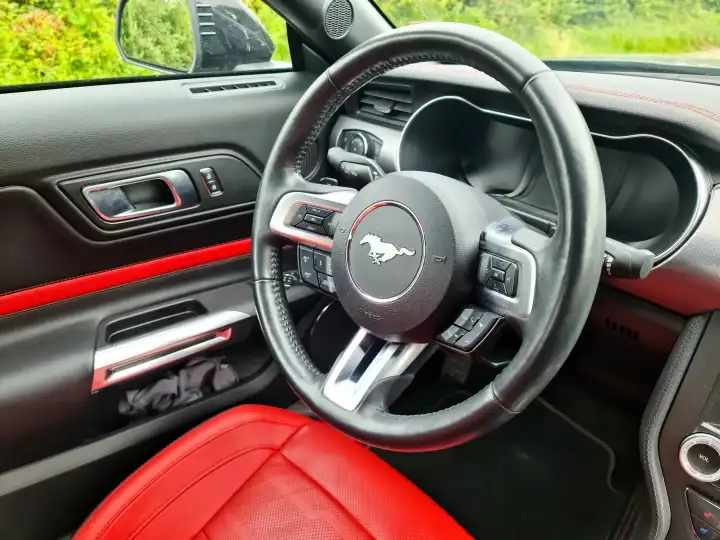 Kiel, Deutschland - 26. Juni 2024: Rote Lederausstattung im Cockpit eines Ford Mustang Modell 2018