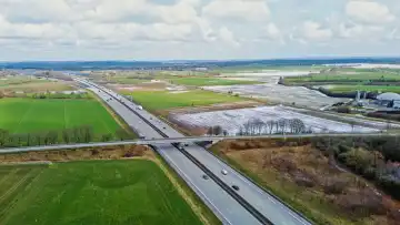 Drohnenansicht der deutschen Autobahn A7 mit einigen Autos und Verkehr in einer grünen Landschaft