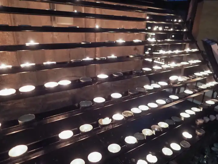 candles lit by worshippers in a church