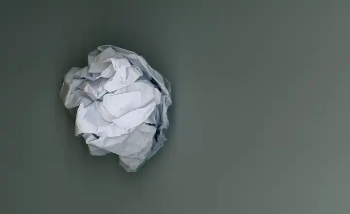 Zerknitterter Papierball mit Kopierraum als Hintergrund