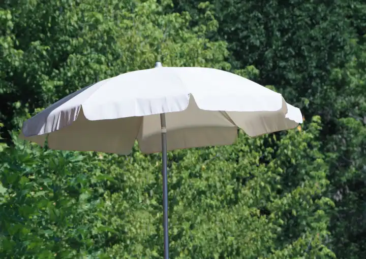 sun umbrella in summer with green trees background