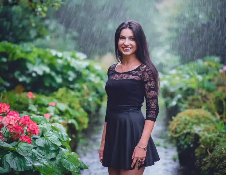 schöne elegante Frau in üppiger Vegetation draußen im Regen in schwarzem Kleid, AI generiertes Bild