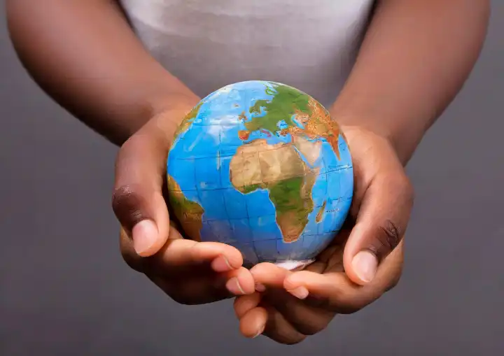 Child holding a world globe in hands, generated with AI