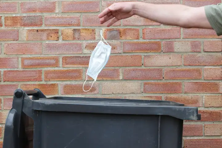 Throwing a covid face mask into a bin