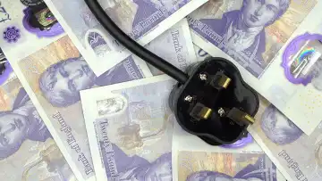 The rising cost of electrcity represented by a British 3 pin plug on some money