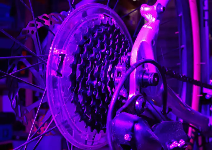 Close up of bicycle gears under a purple light