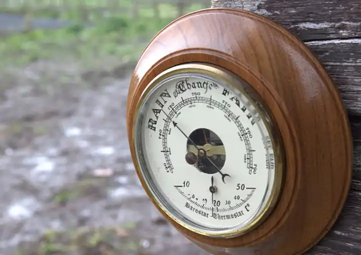 Outdoor barometer pointing to rain in rain shower in British summer