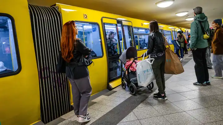 Passengers board a Berliner Verkehrsbetriebe (BVG) subway train at Alexanderplatz subway station in Berlin.